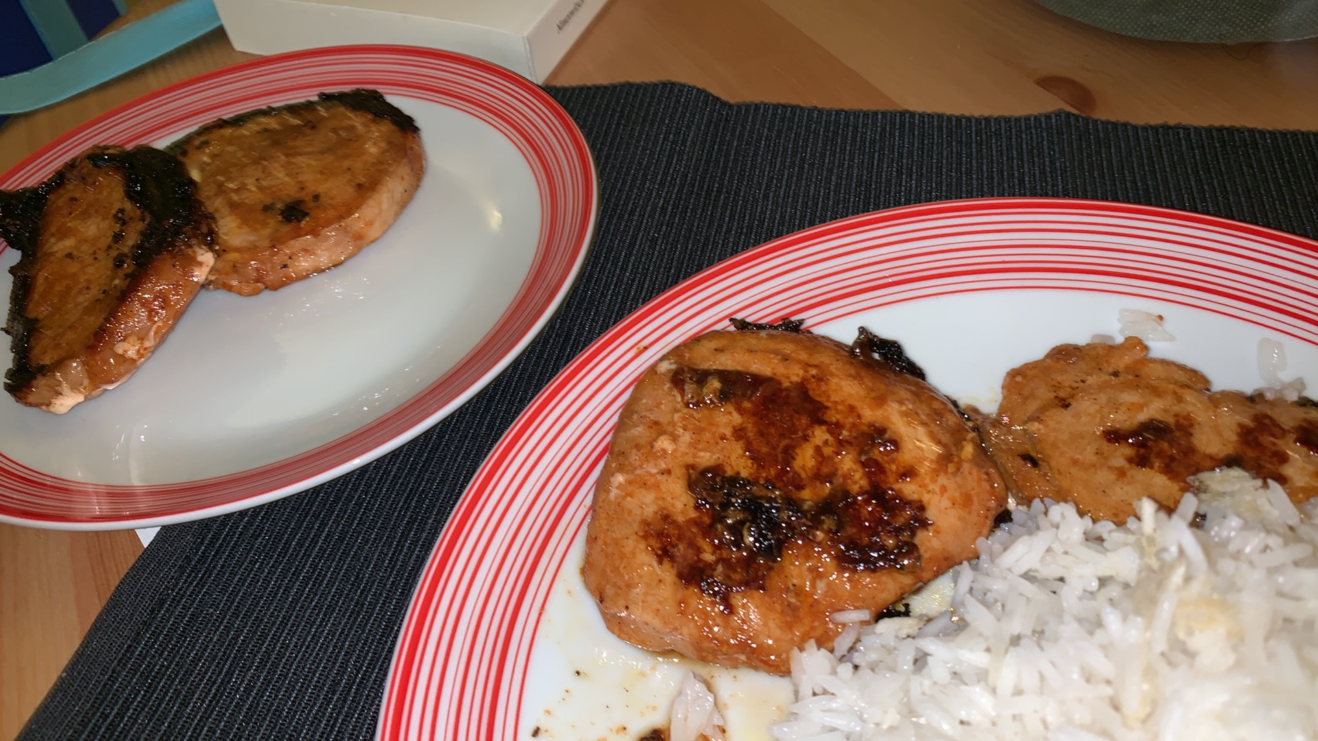 Two plates of food, one of the plates has rice